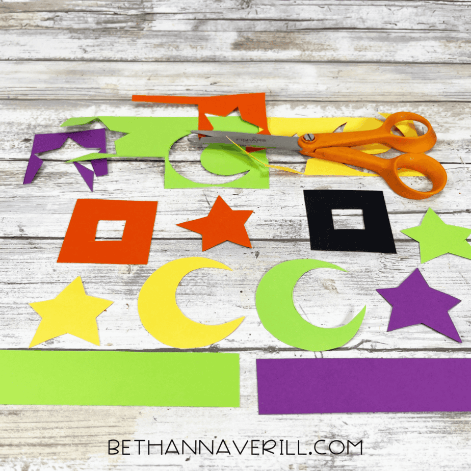 Cut-out paper shapes for hat decorations with scissors beside them.