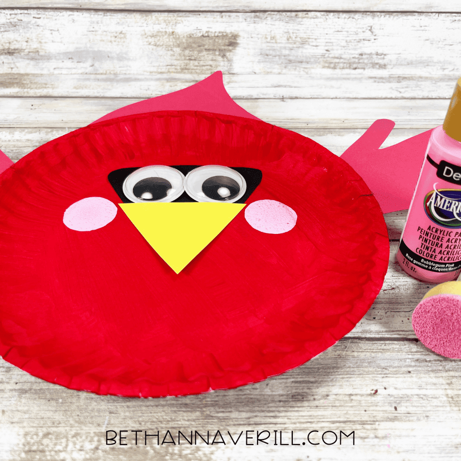 The cardinal craft with two pink painted cheeks added to the red paper plate face using a sponge dauber and pink acrylic paint.