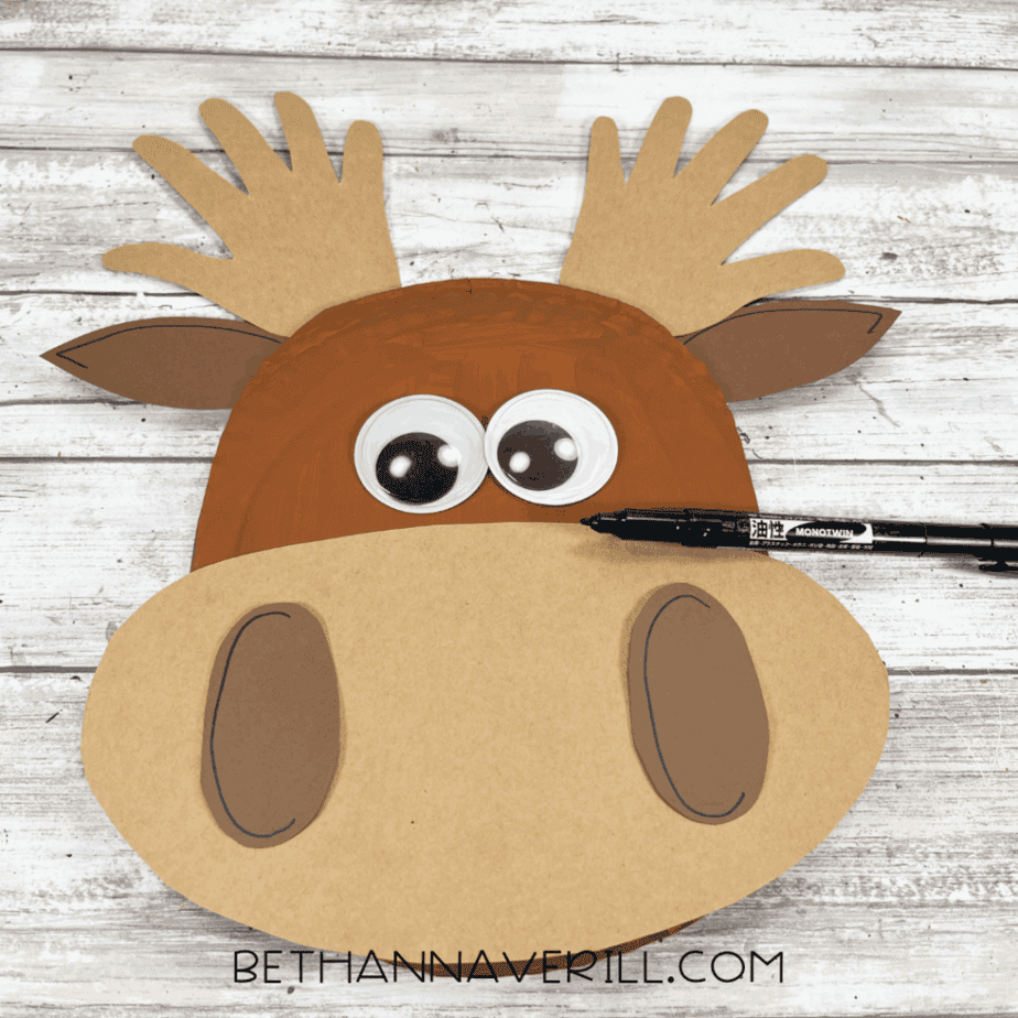 Paper plate moose with details drawn on the ears using a black marker.