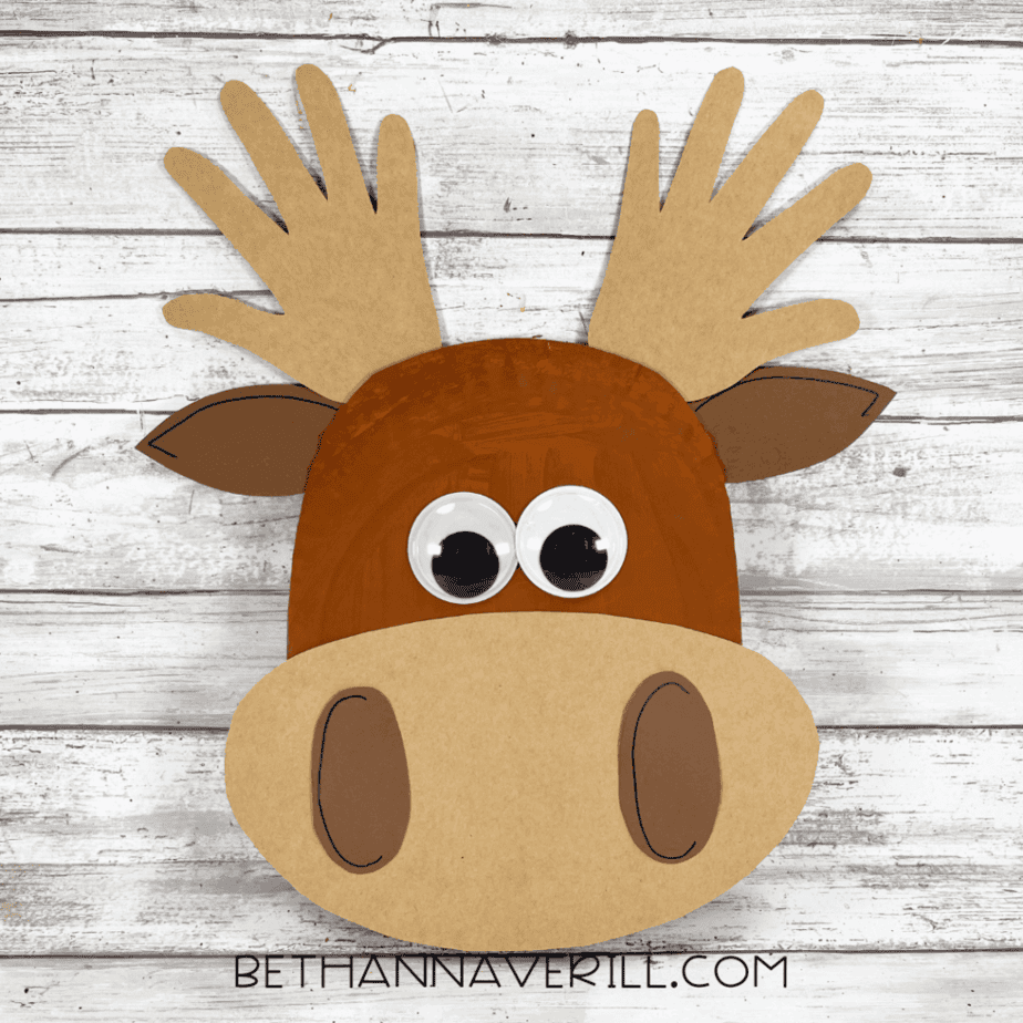 Finished paper plate moose craft with googly eyes, cardstock muzzle, ears, and handprint antlers.