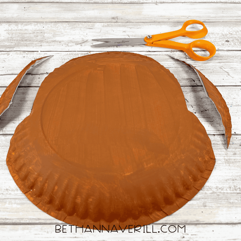 Painted paper plate with the sides cut off following the traced moose head shape.