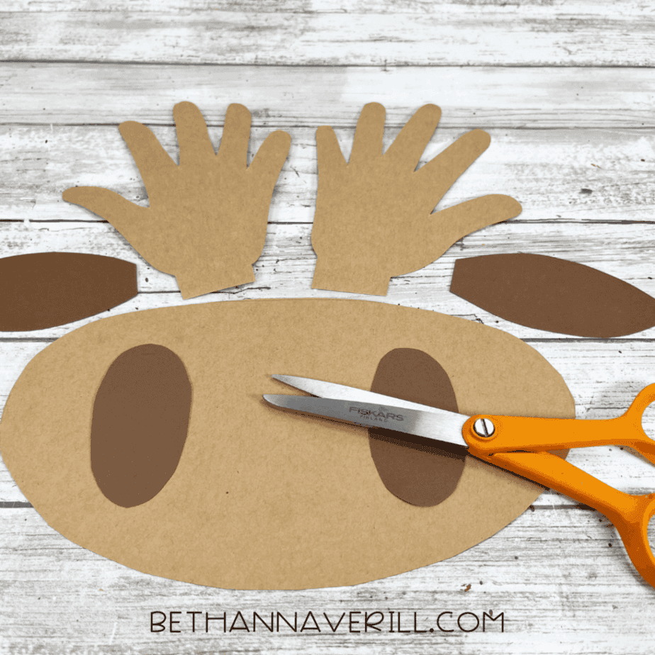 Cut-out brown cardstock pieces for the moose craft, including handprint antlers, muzzle, and ears.