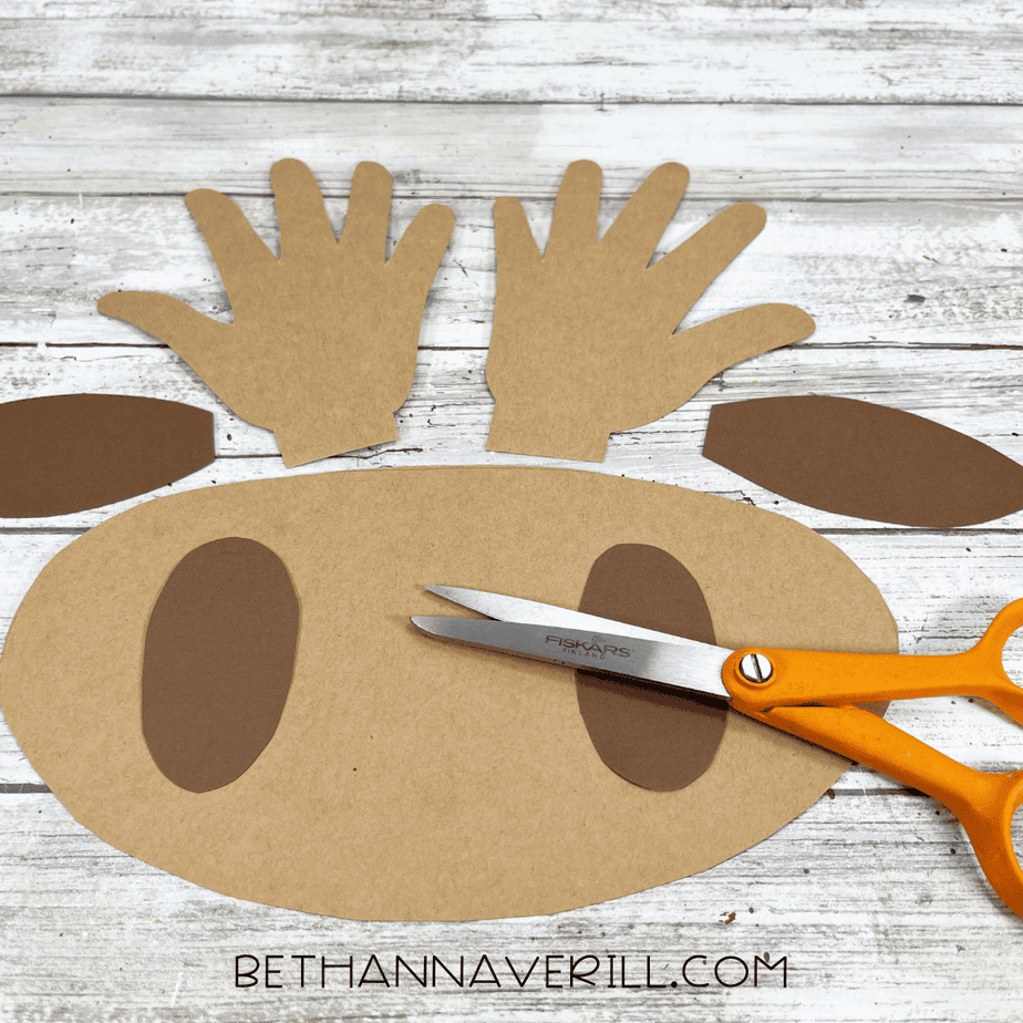 Cut-out brown cardstock pieces for the moose craft, including handprint antlers, muzzle, and ears.