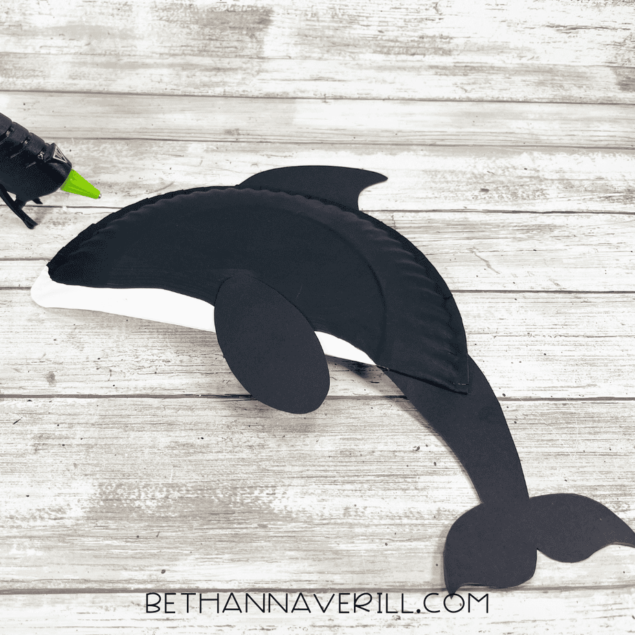 Orca craft being assembled with the black painted plate half and cardstock pieces glued into place.