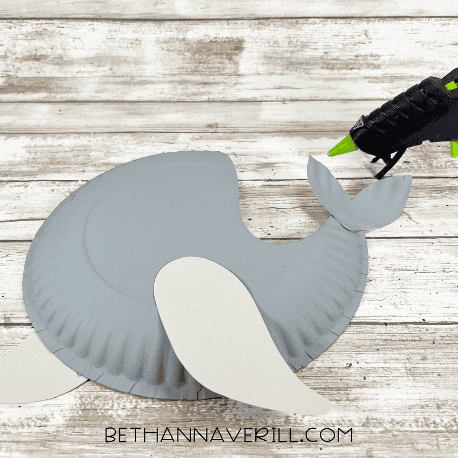 The seal craft partially assembled with flippers and tail glued to the gray paper plate body.