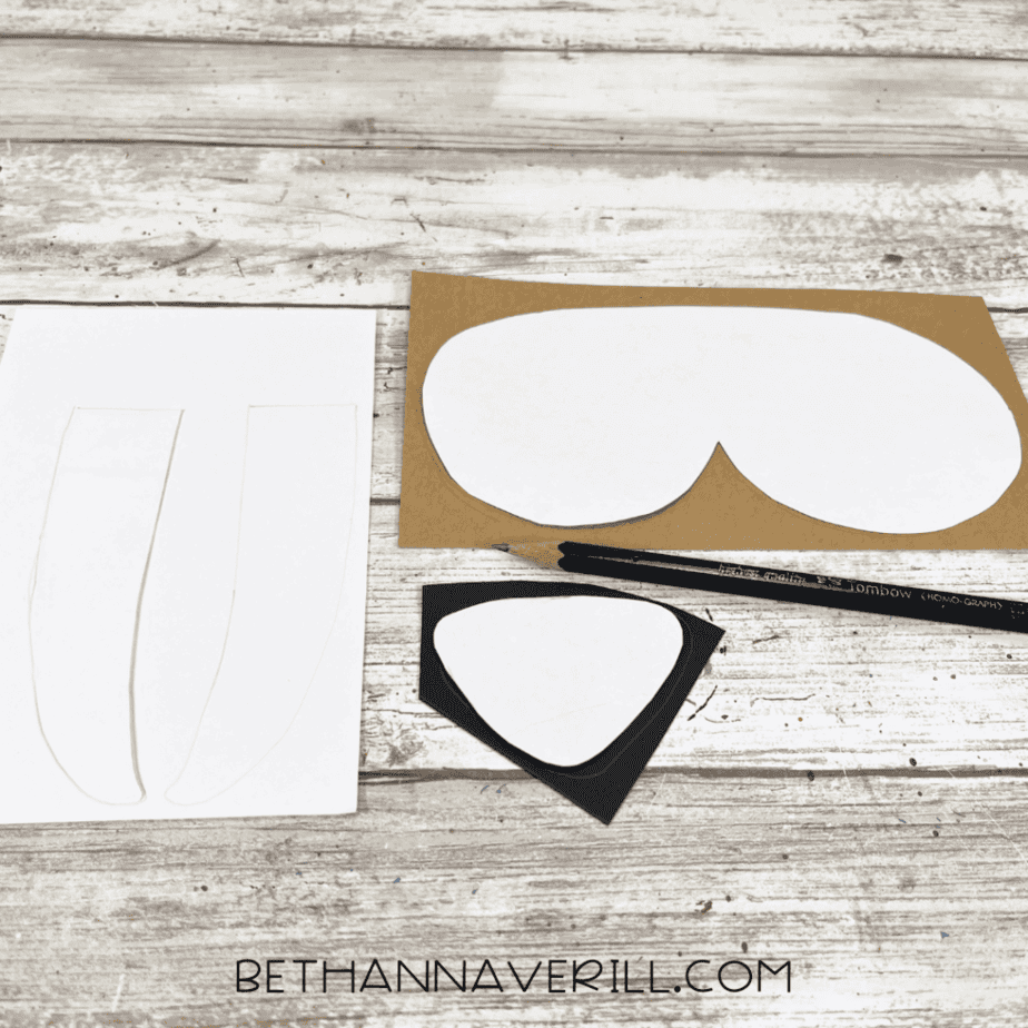Walrus craft template pieces traced onto white, brown, and black cardstock with a pencil.