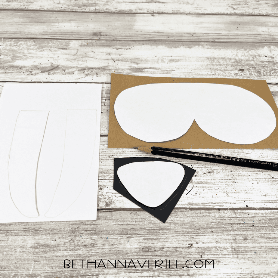 Walrus craft template pieces traced onto white, brown, and black cardstock with a pencil.