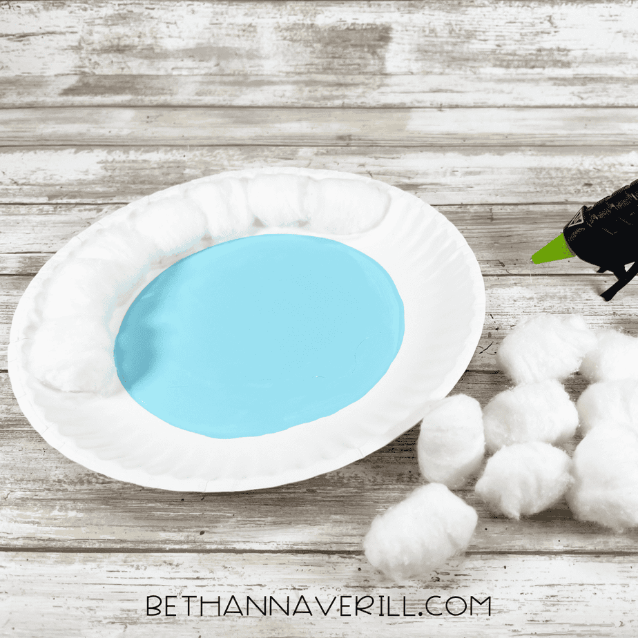 Cotton balls glued around the rim of a painted blue paper plate to form the yeti’s fluffy fur.