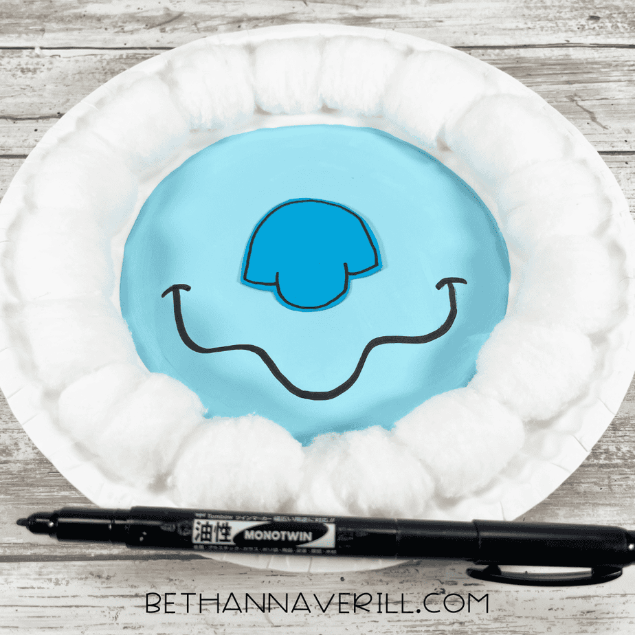 Yeti’s blue cardstock face glued to the center of the plate, with a drawn-on black smile and cotton ball fur around the edge.