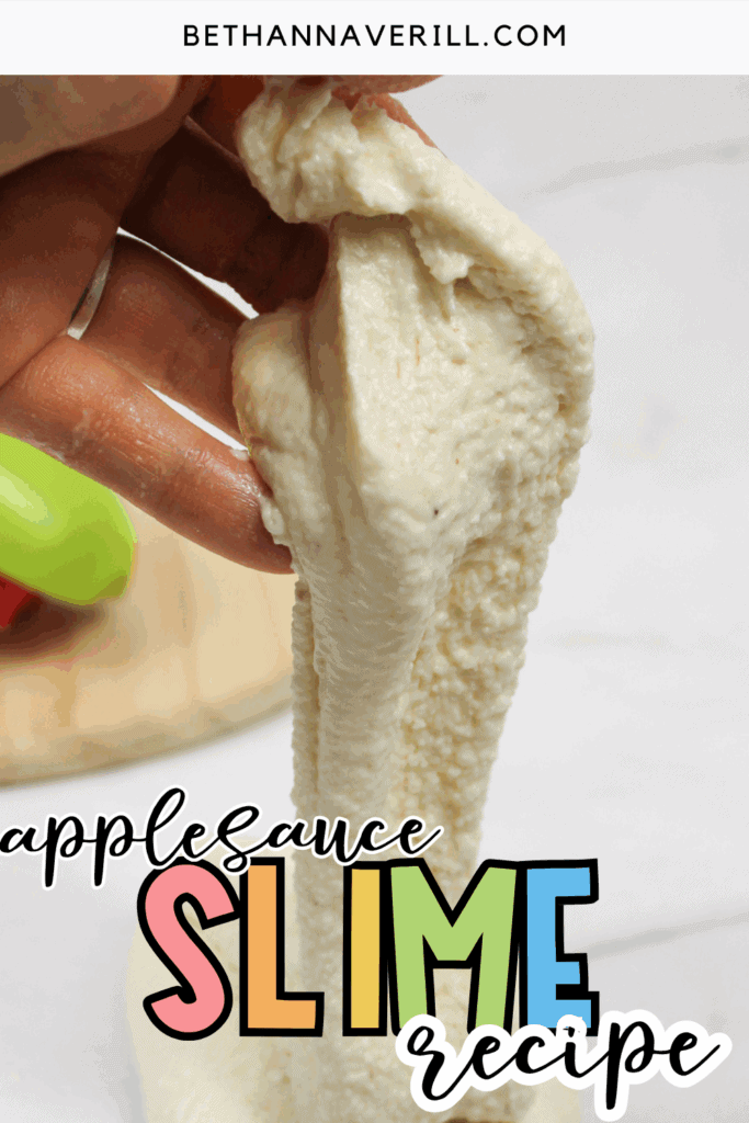 Close-up of applesauce slime folded and stretched between fingers.