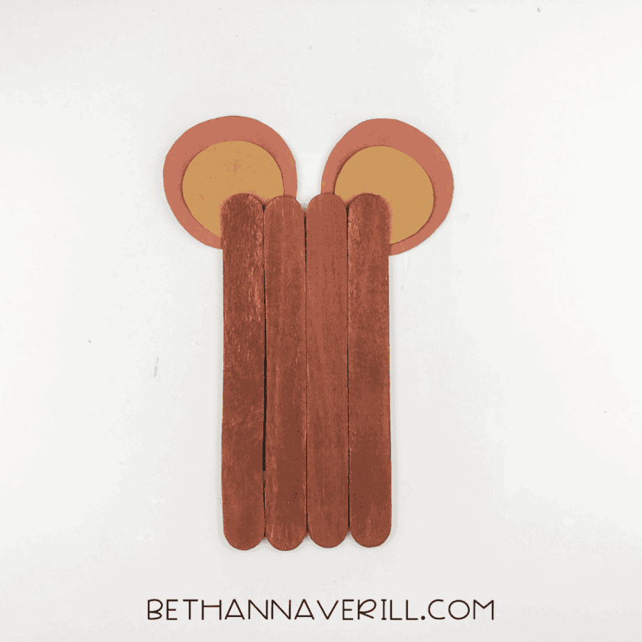 Brown-painted craft stick base with two paper ears attached at the top.