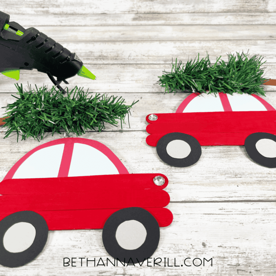 Christmas trees glued on top of red popsicle stick Christmas cars