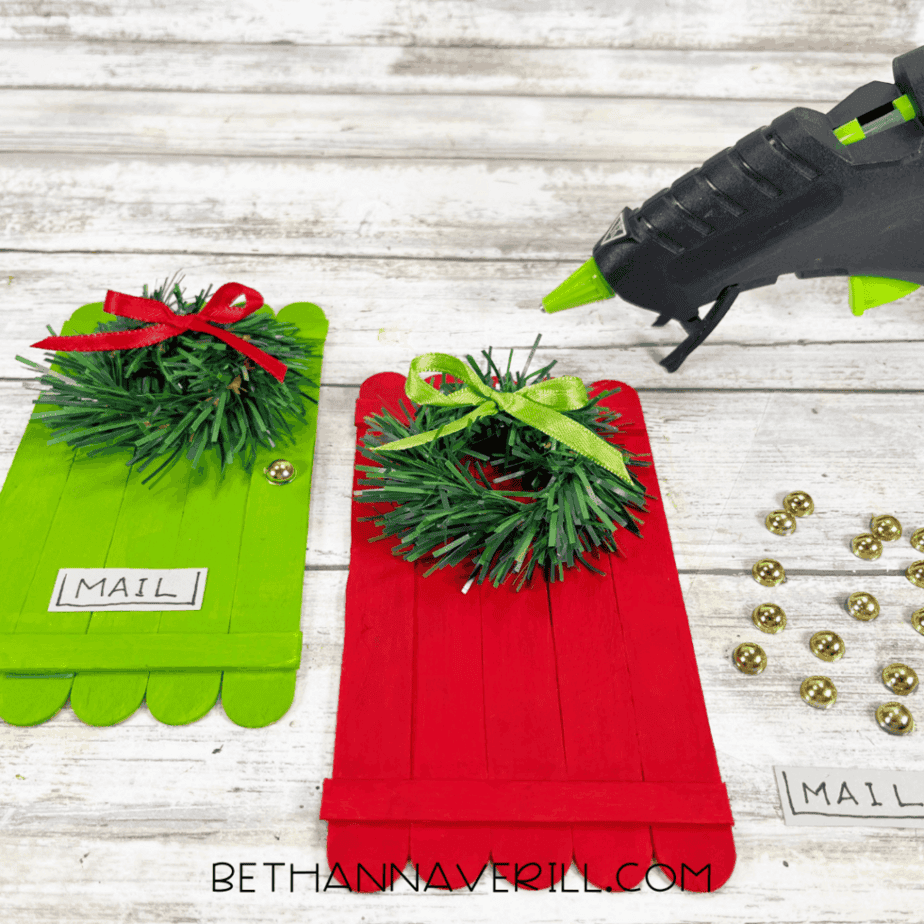 Christmas door popsicle stick crafts with wreaths, bows, and mail details