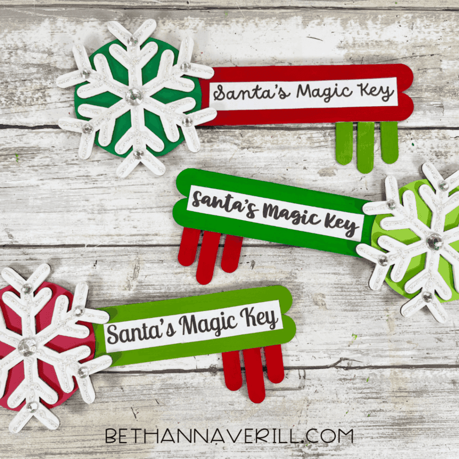 Multiple completed Santa Magic Key popsicle stick crafts arranged on a rustic wood background with labels attached.