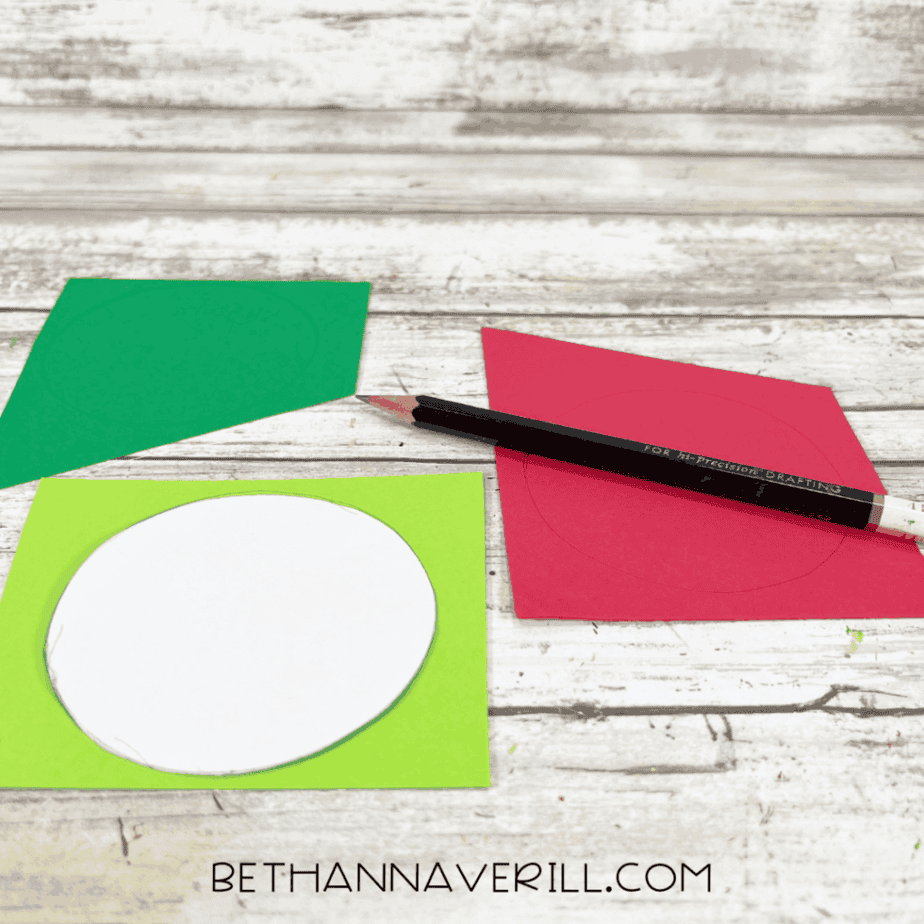 Cardstock circles traced and cut out in red and green to create the backing for Santa Magic Key snowflake decorations.