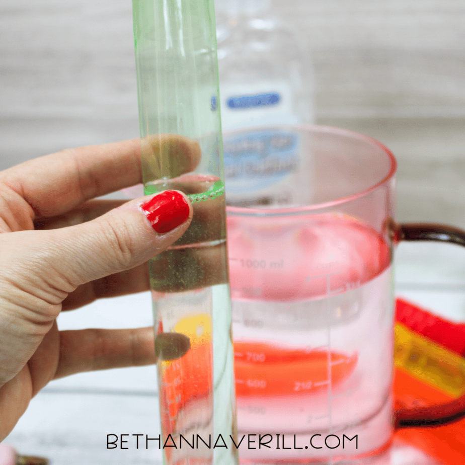 Water being poured into a bubble tube for DIY sensory bottle
