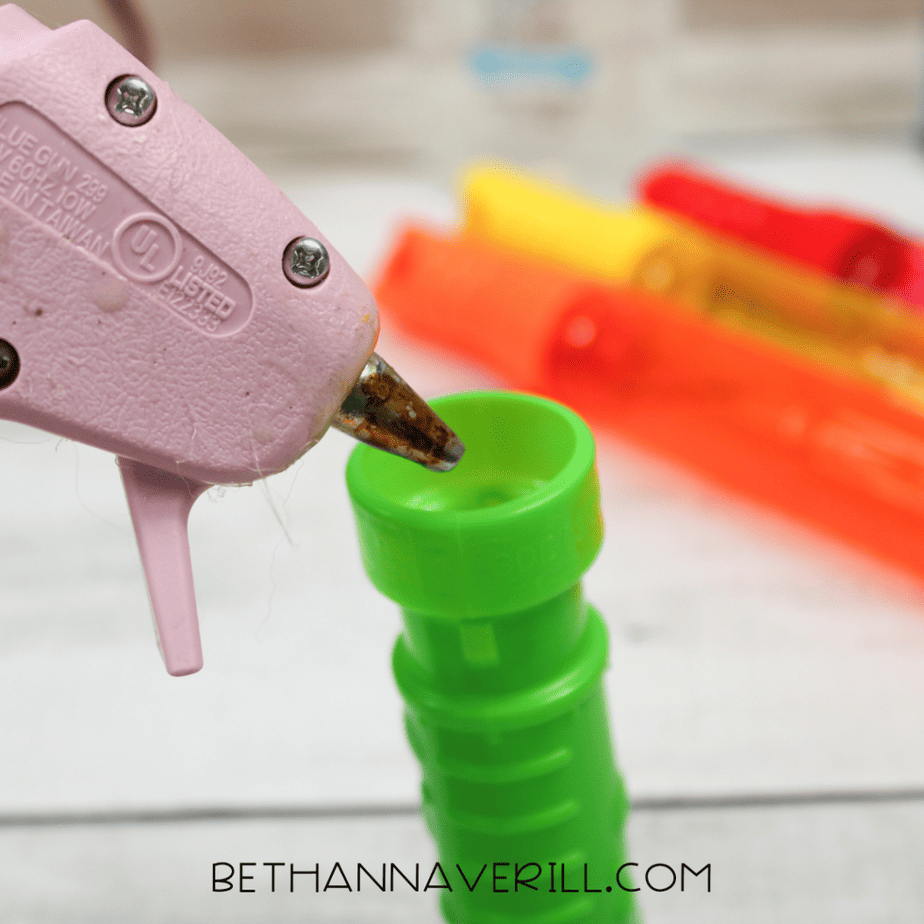 Hot glue being applied to bubble wand cap to securely seal sensory bottle