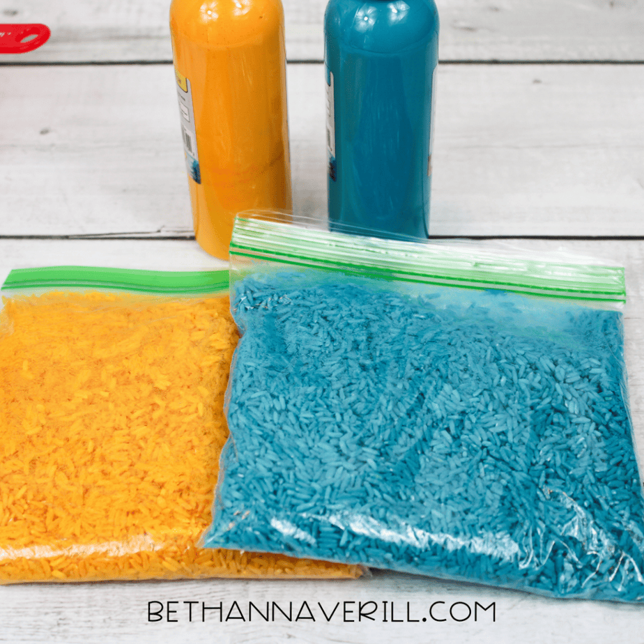 Sealed zip-top bag being shaken to coat rice evenly with paint.