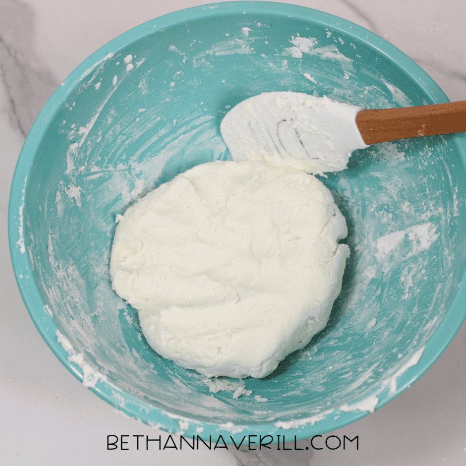 Thick white dough-like mixture formed into a smooth ball inside a teal bowl.