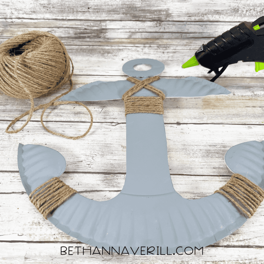 Gray anchor-shaped paper plate with twine wrapped around multiple sections of the anchor.