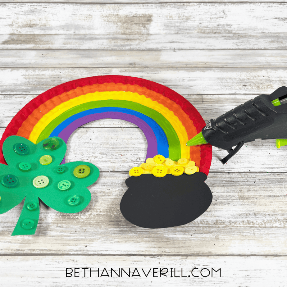 Shamrock and pot of gold being glued to the painted rainbow.