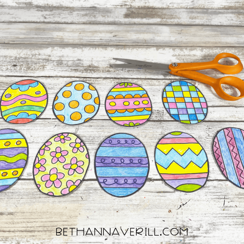 Cut out colored Easter egg shapes arranged in a row with scissors nearby
