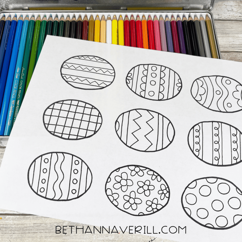 Printed Easter egg coloring page with black outlines placed over colored pencils