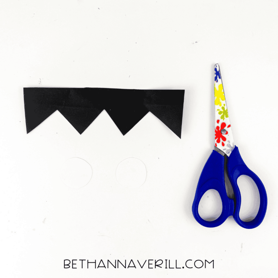 Black paper zigzag strip cut to create Frankenstein hair for a Halloween popsicle stick craft.