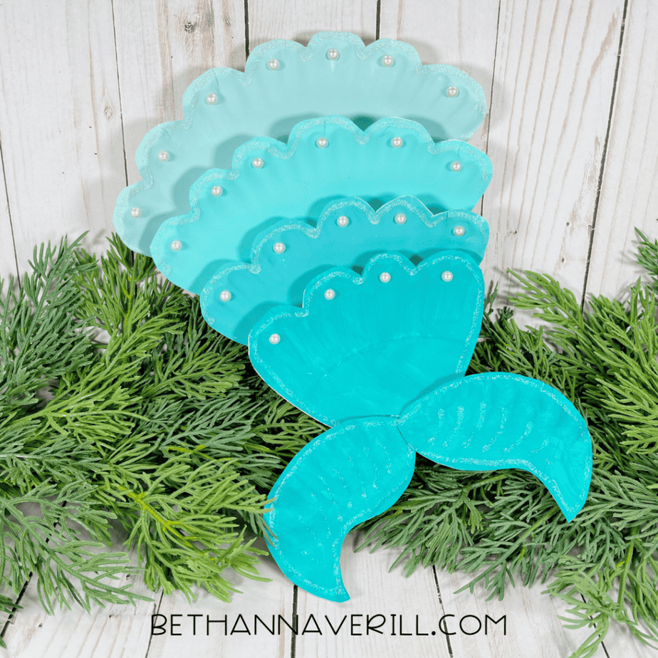 Completed mermaid tail paper plate craft decorated with pearl beads along the scalloped edges.