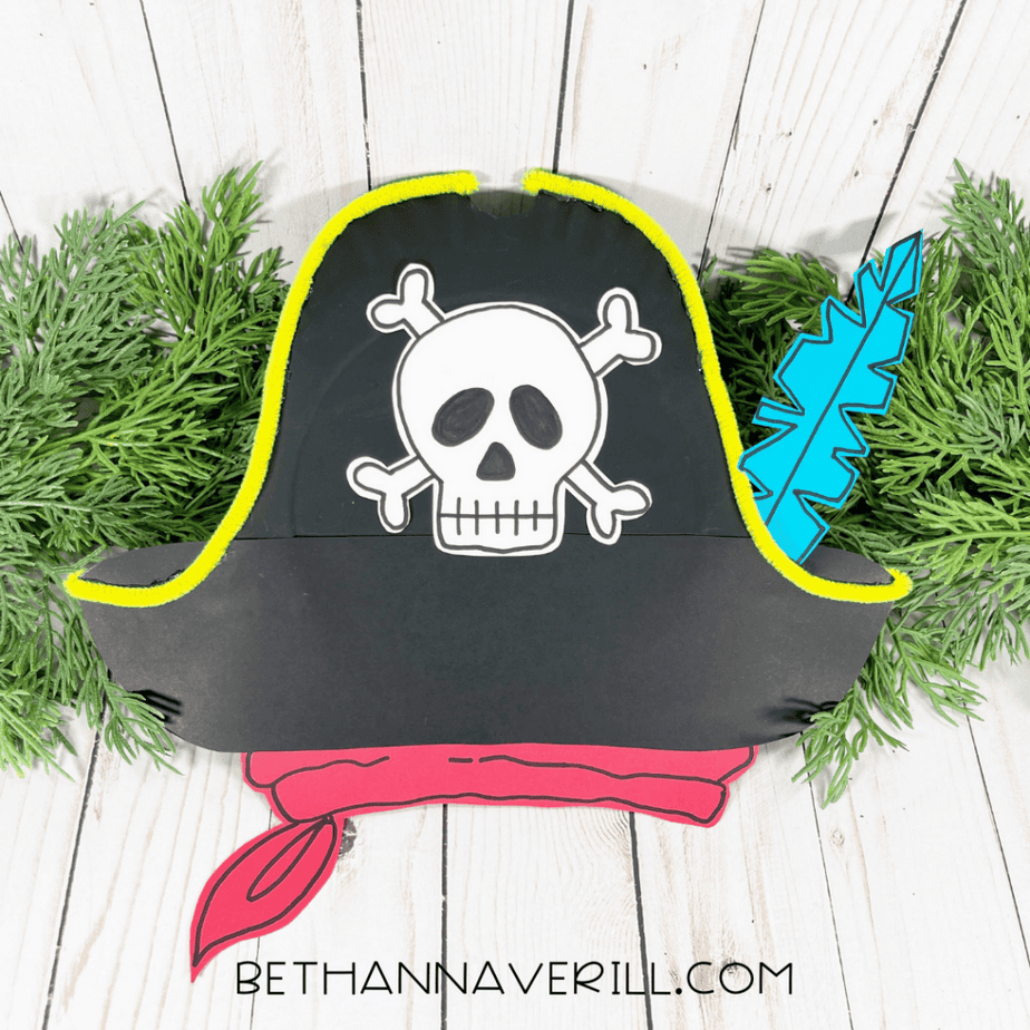 Finished pirate hat paper plate craft displayed with greenery.