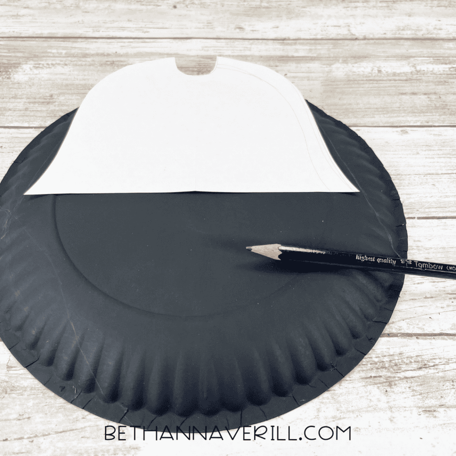 Tracing pirate hat template onto painted paper plate.