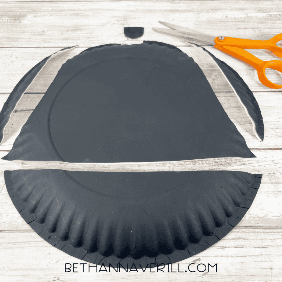 Cutting paper plate to shape the pirate hat.