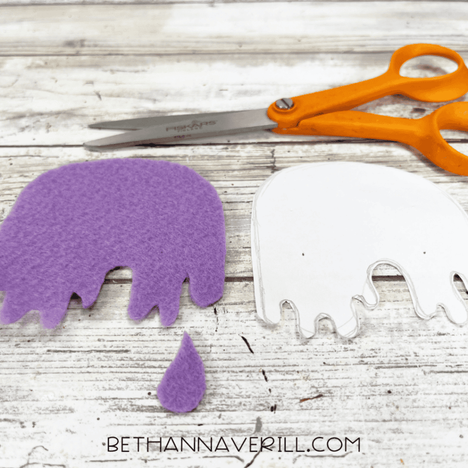The purple felt cut into a rounded dripping shape next to the paper template and a small teardrop-shaped felt piece.