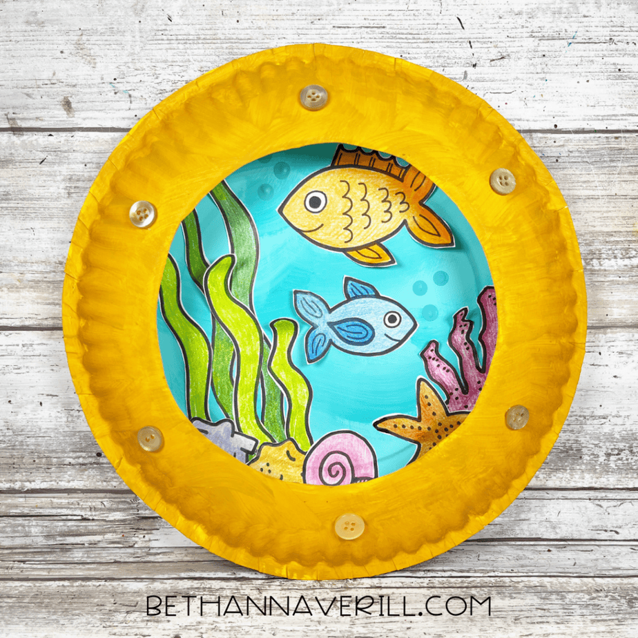 Finished paper plate craft with yellow frame and small round embellishments attached around the edge.