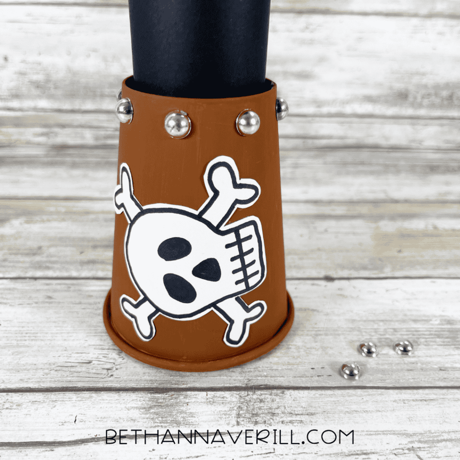 Silver gem “studs” attached around the paper cup opening to decorate the pirate telescope.