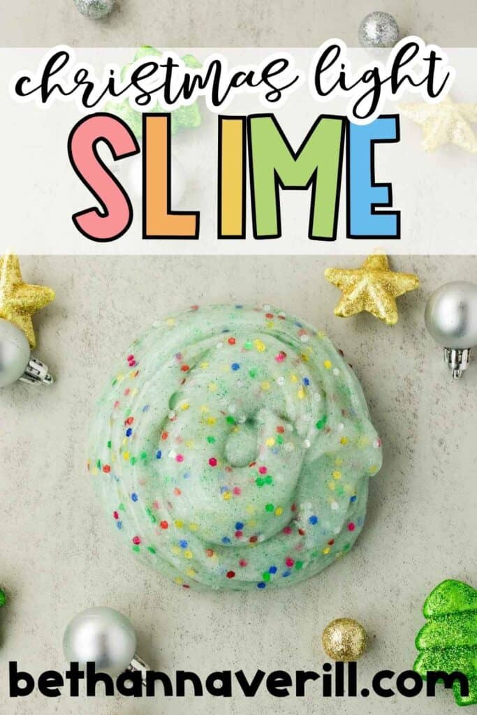 Pale green confetti slime is coiled on a gray surface and surrounded by silver ornaments. Gold stars. And green Christmas tree decorations. Overlaid text reads “christmas light SLIME” and “bethannaverill.com”.