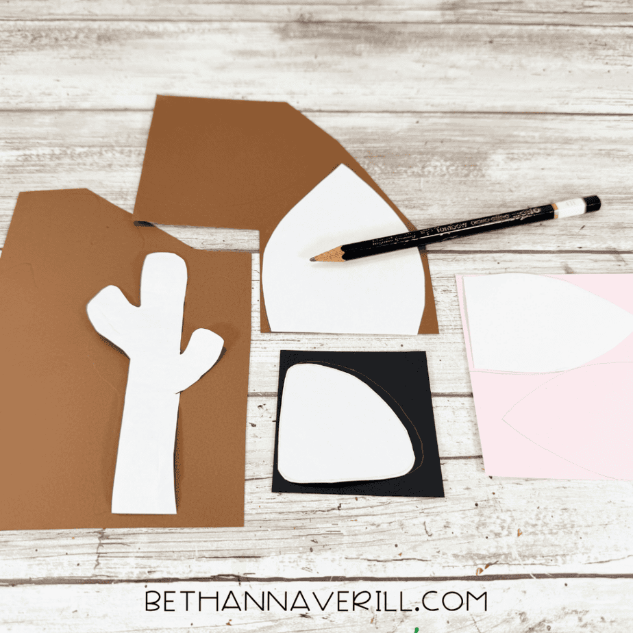 Brown cardstock with paper templates for antlers, ears, and a nose being traced with a pencil.