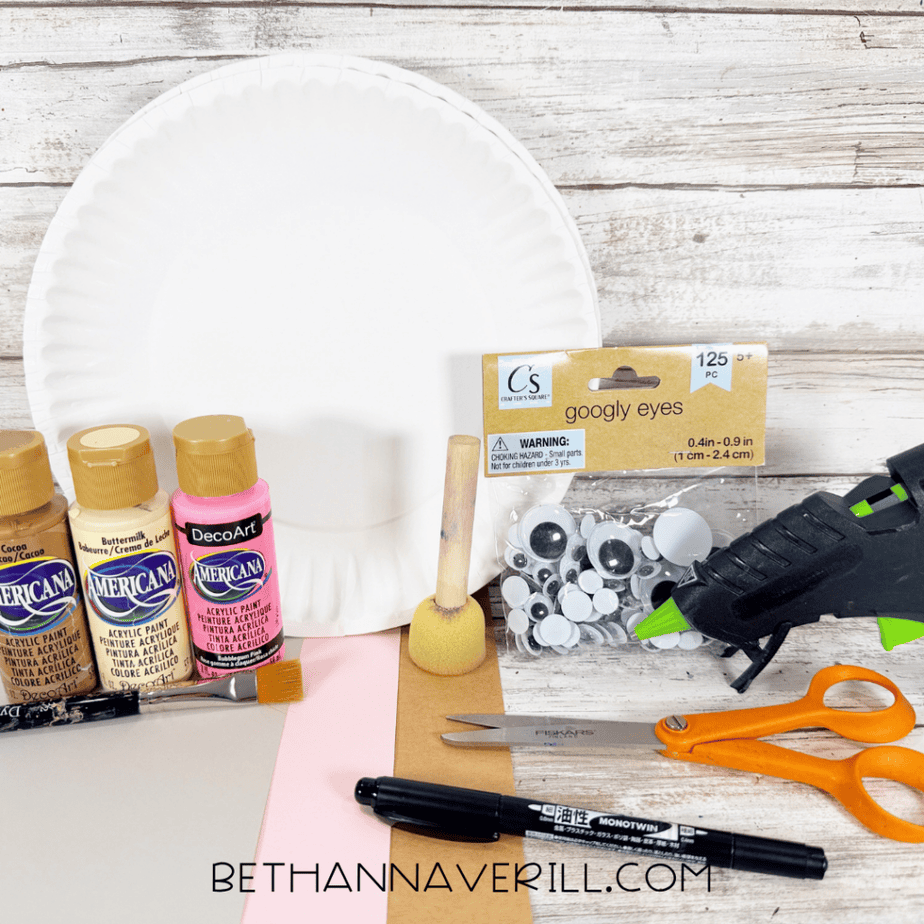 White paper plates with brown, cream, and pink acrylic paint, a foam brush, paintbrush, googly eyes, hot glue gun, scissors, black marker, and sheets of brown, gray, pink, and white paper.