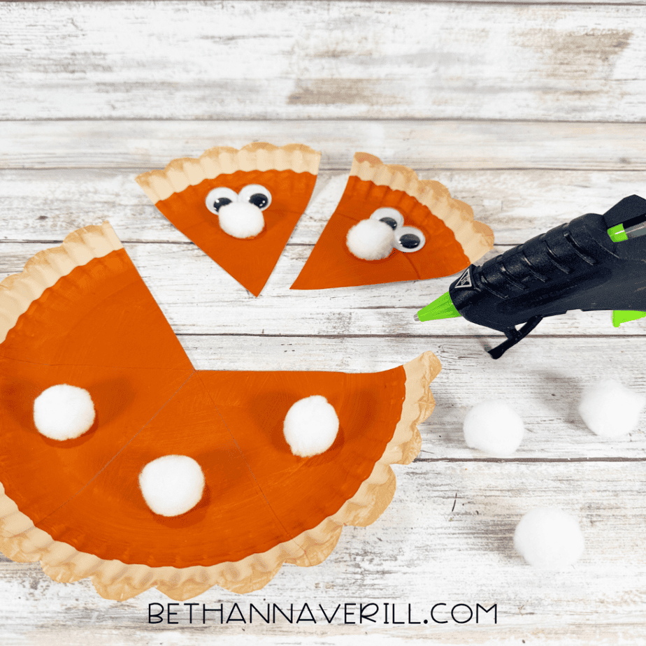 Pumpkin pie slices and remaining pie section decorated with white pom poms and googly eyes.